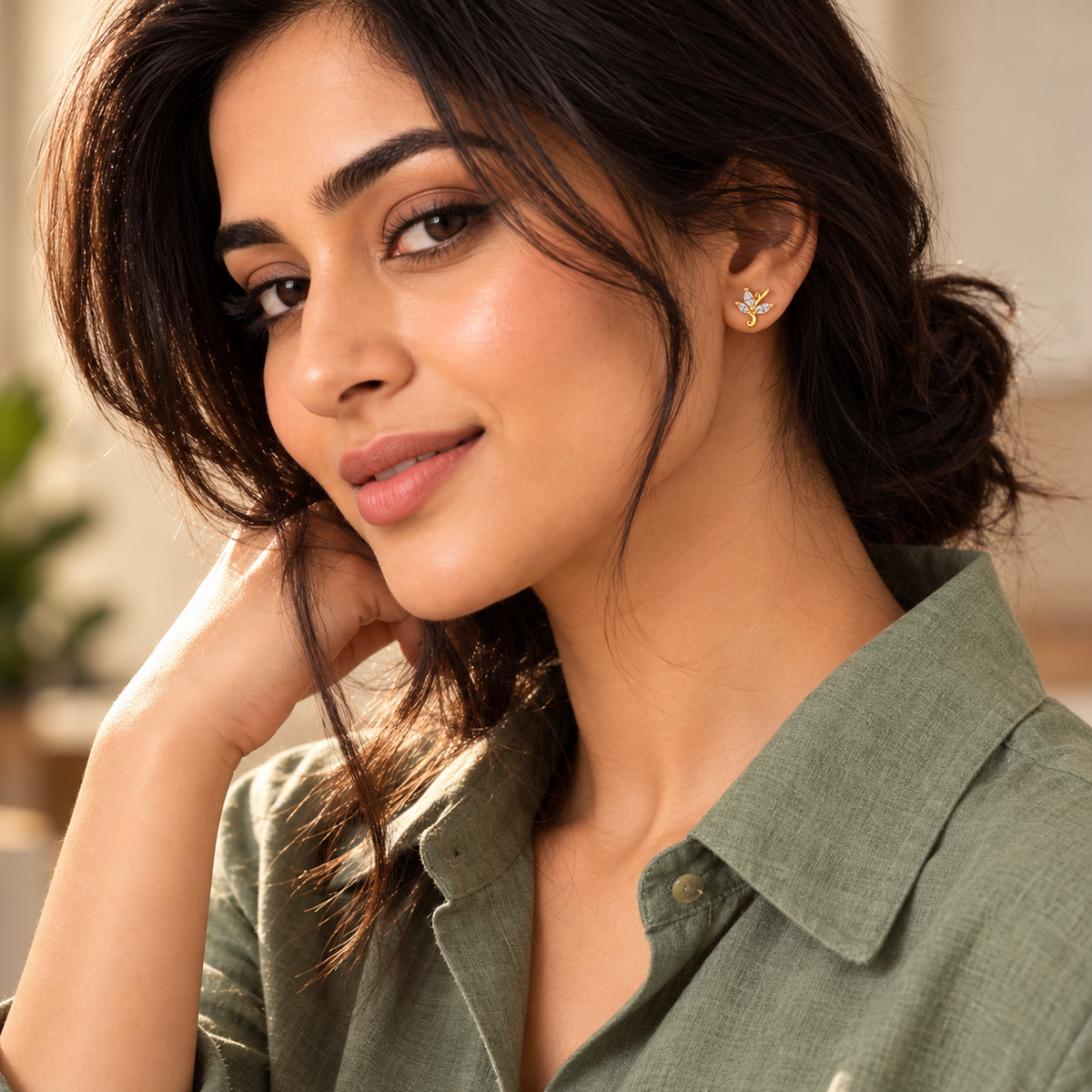 Noya wearing gold marquise leaf stud earrings with hair in a relaxed low bun.
