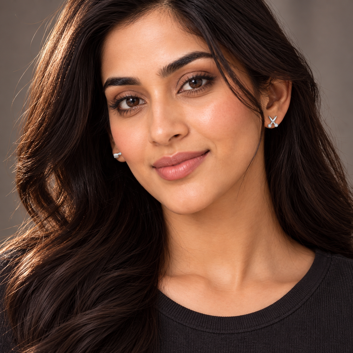 Portrait of woman wearing asymmetric silver comb and shears stud earrings.