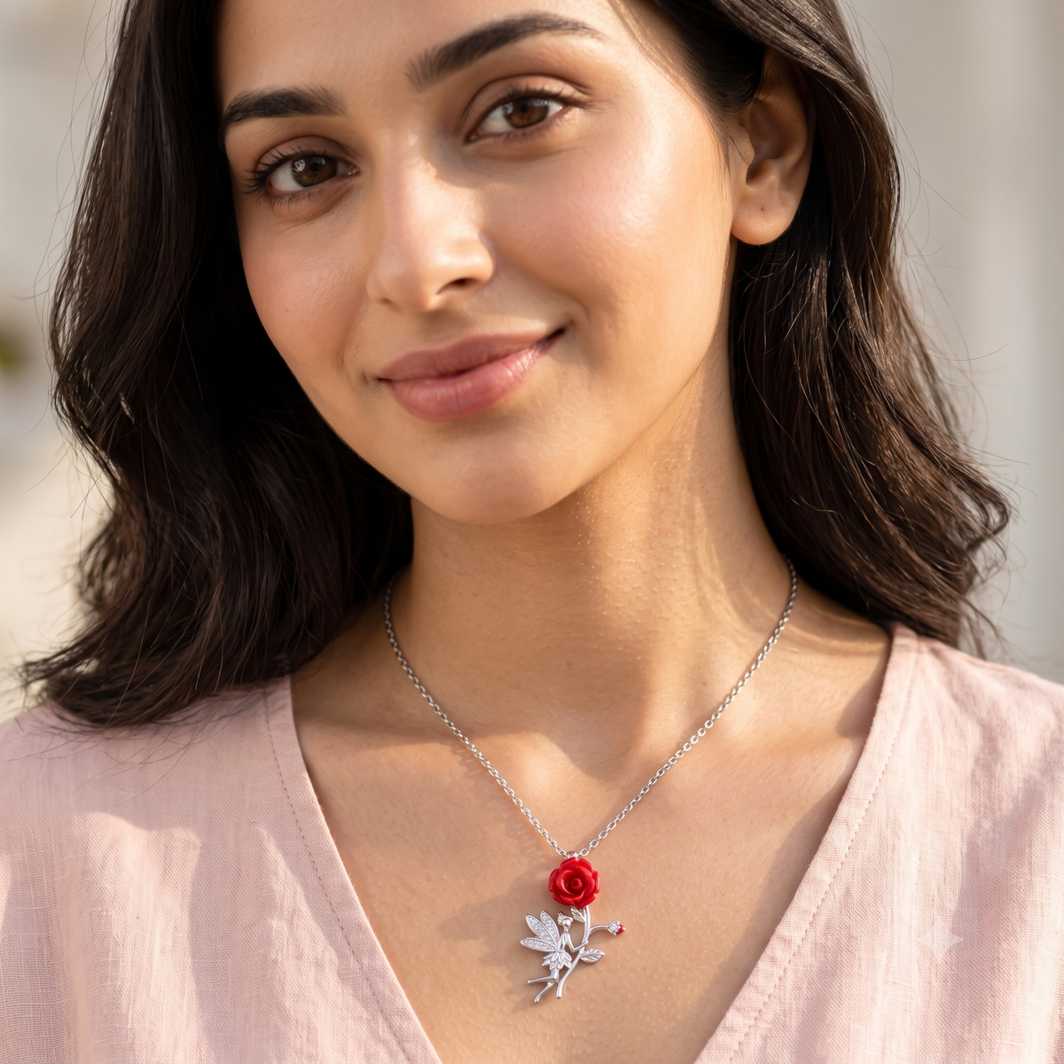 Close-up of the silver fairy necklace on Noya's neck as she smiles warmly in the sunlight.