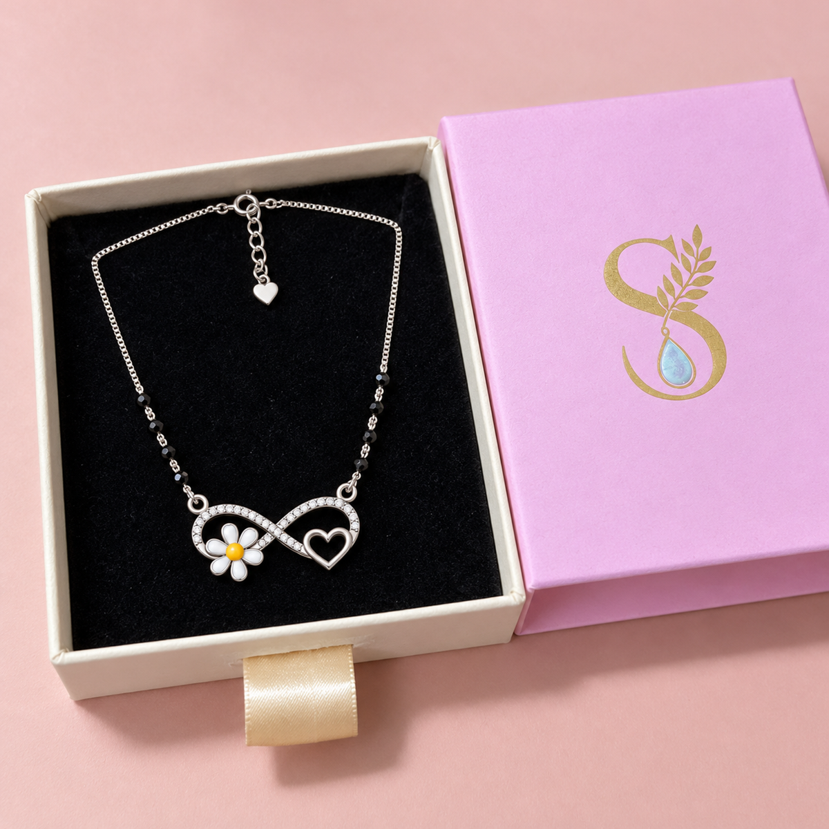 Silver mangalsutra necklace stored in a magenta pink jewelry drawer box with black velvet interior.