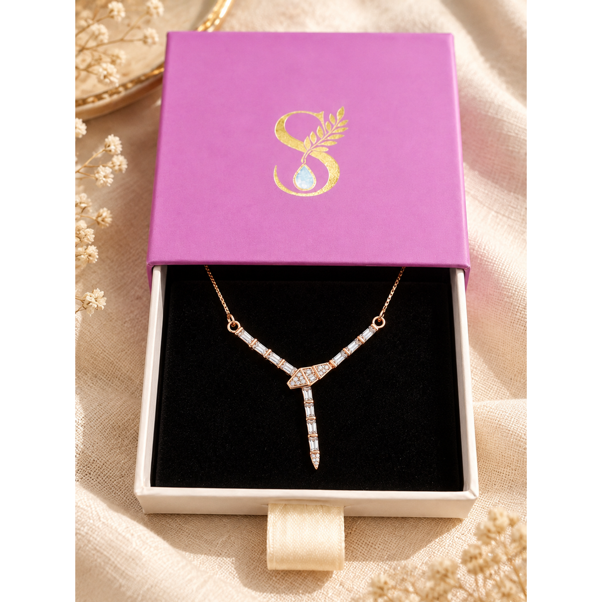 Rose gold Y-necklace displayed inside Silvanya magenta drawer gift box with gold foil monogram.