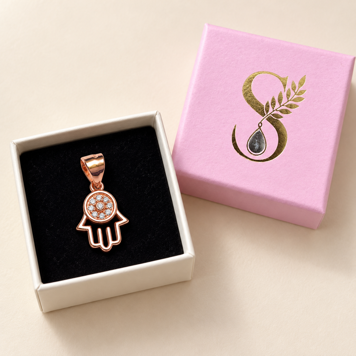 Rose gold Hamsa pendant inside Silvanya pale pink gift box on black velvet.