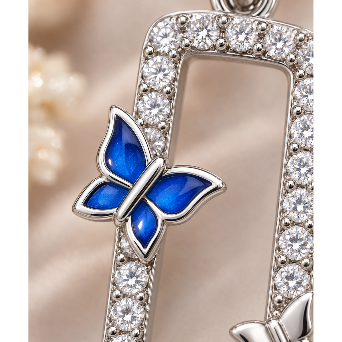 Macro detail of clear cubic zirconia stones and blue enamel butterfly accent on sterling silver pendant.