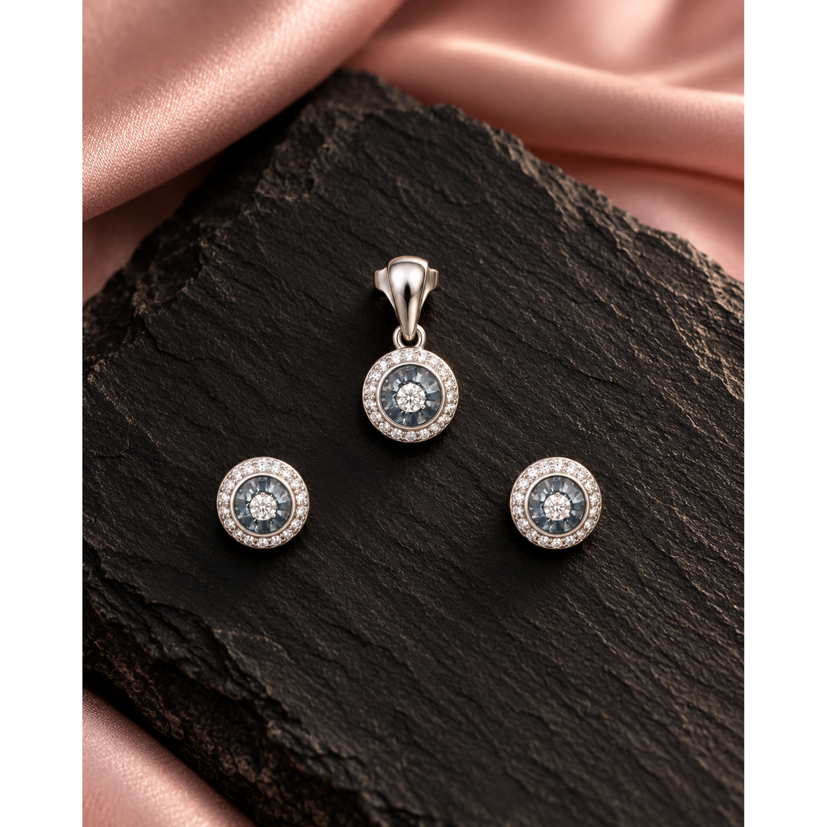 Jewellery set arranged on dark slate with soft blush pink silk.