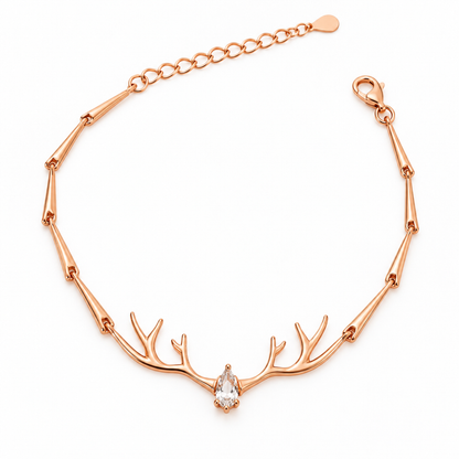 Rose gold silver bracelet with central antler motif and pear-cut stone on a plain white background.
