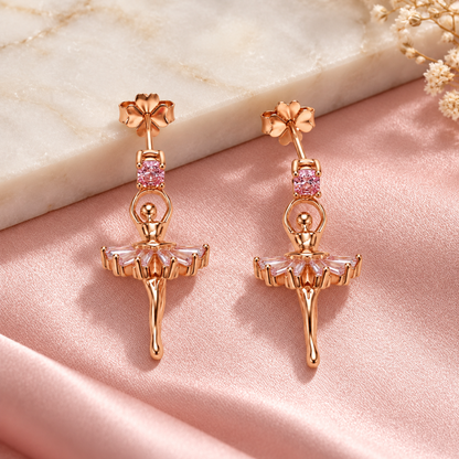 Pair of ballerina drop earrings resting on blush pink satin and ivory marble.