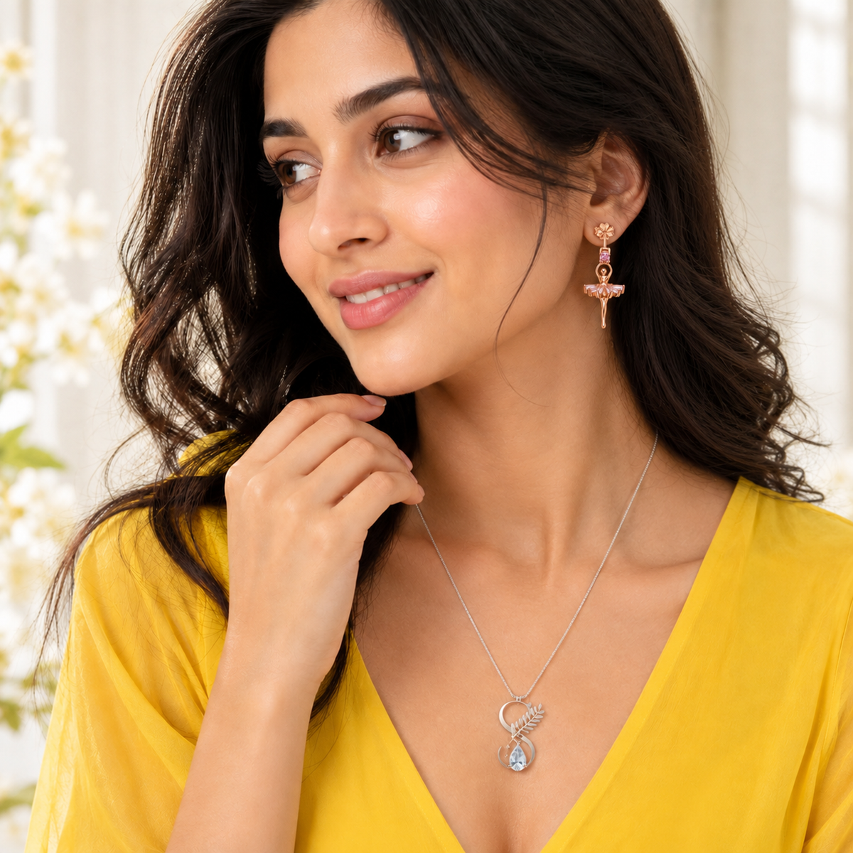 Frontal shot of a woman wearing ballerina drop earrings with a pink off-shoulder knit top.