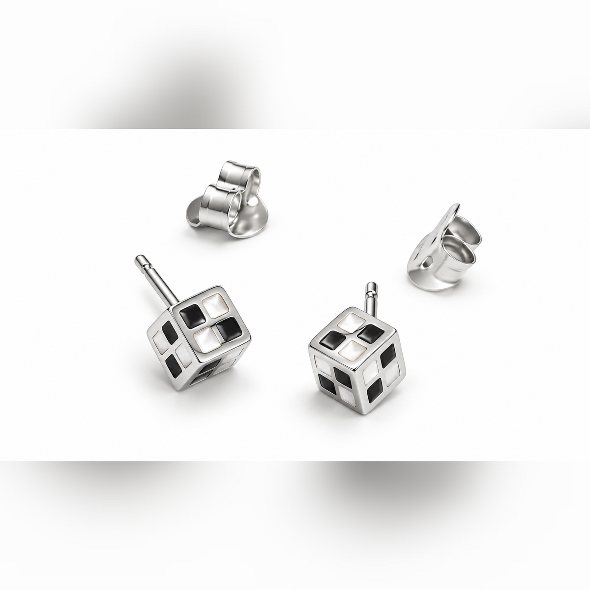 Pair of geometric cube stud earrings with black and white checkerboard pattern on a white background.