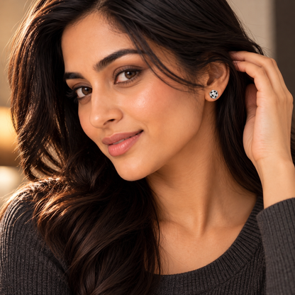 Woman smiling while wearing a cube stud earring with black and white checkerboard detailing.