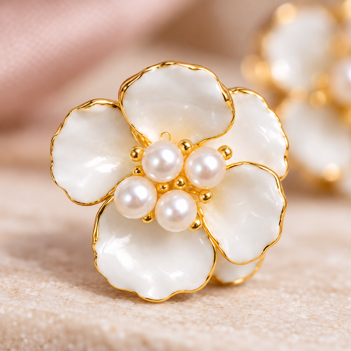 Extreme macro shot highlighting the central pearl cluster and glossy white enamel of a floral stud earring.