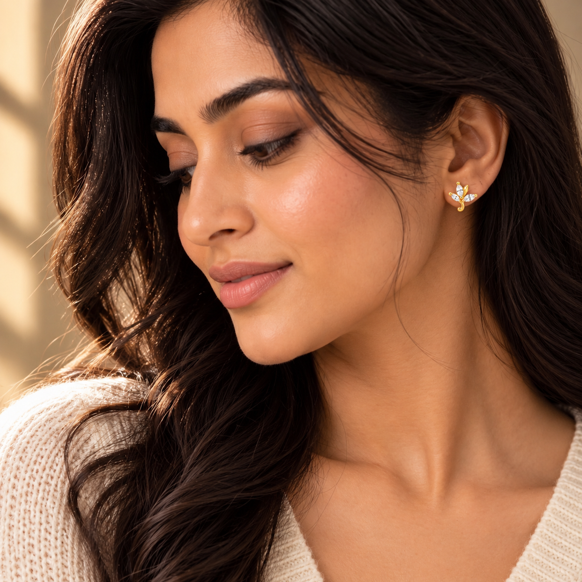 Close-up of Noya wearing the gold marquise leaf stud earring on her earlobe.
