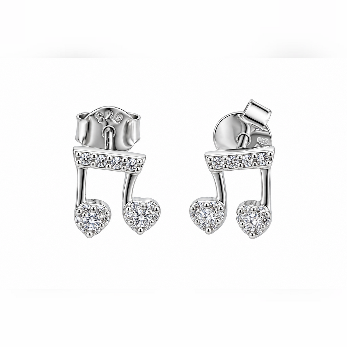 Pair of silver musical note stud earrings with cubic zirconia stones on a seamless white background.