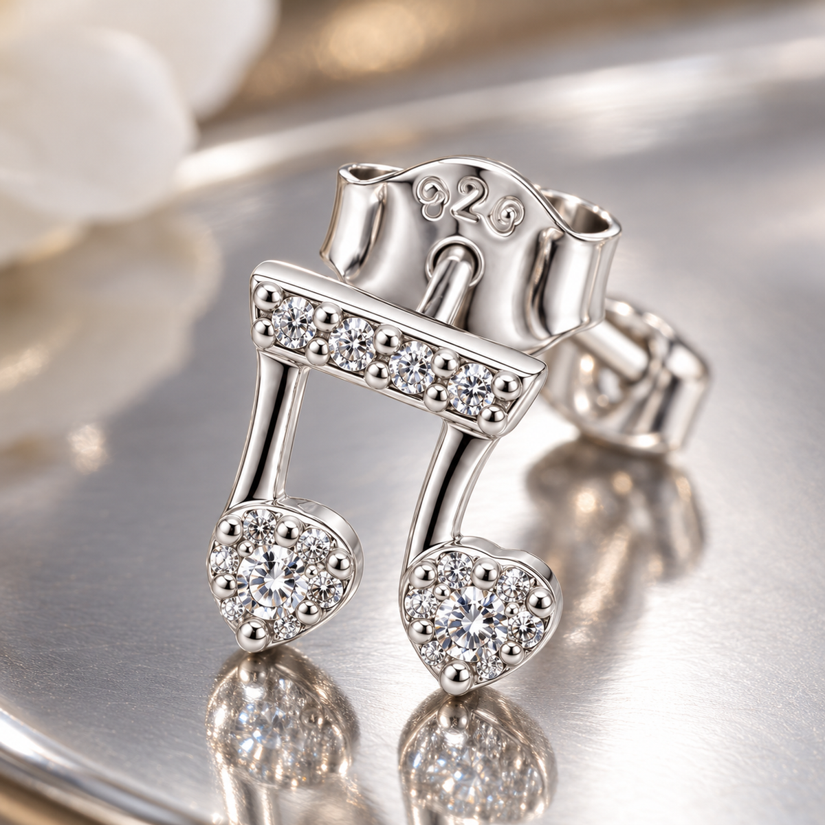 Macro shot of a silver musical note stud earring showing pavé stones and fine metal craftsmanship.