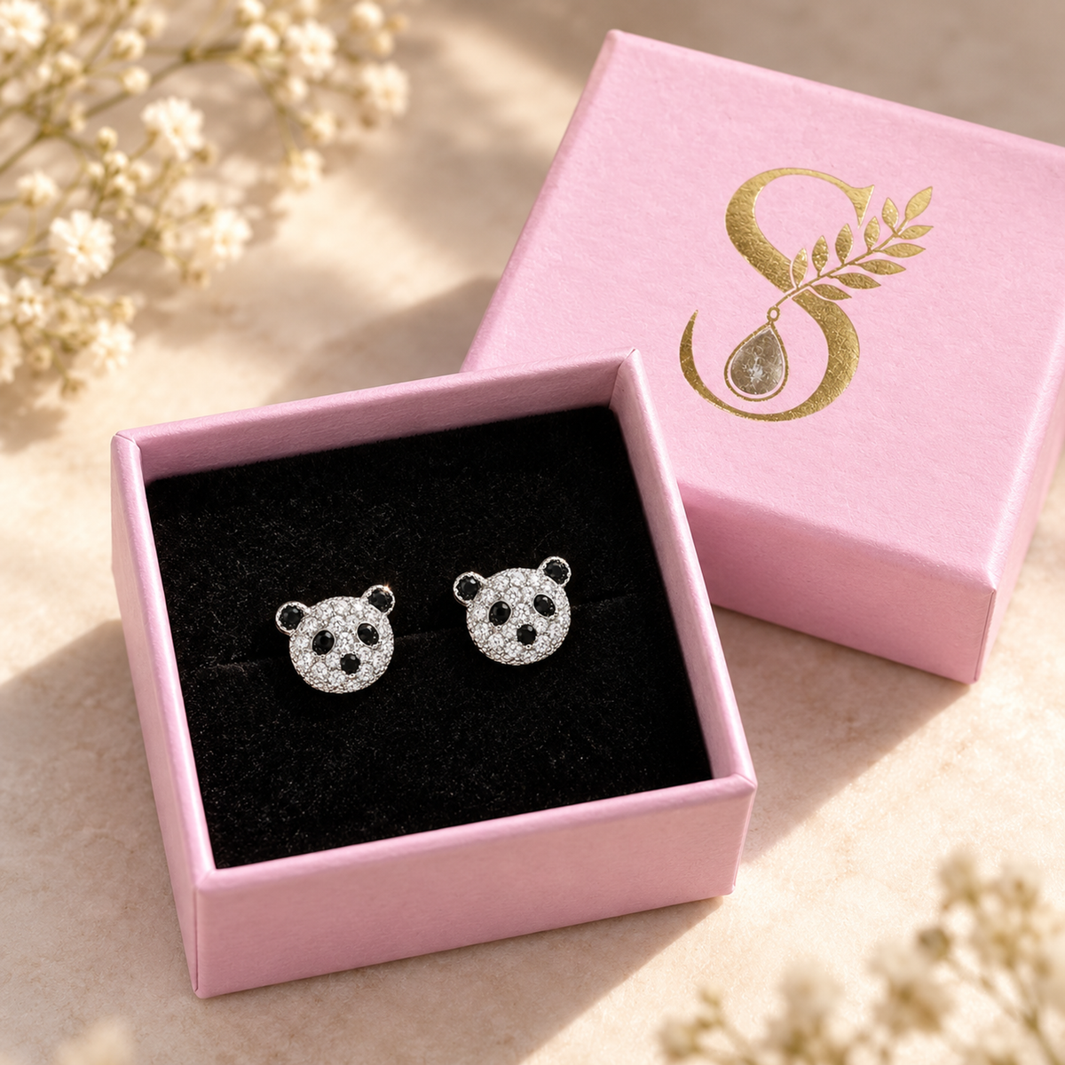 Silver panda earrings presented inside a Silvanya blush pink gift box on black velvet.
