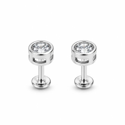 Pair of clear bezel-set silver stud earrings on a seamless white background.