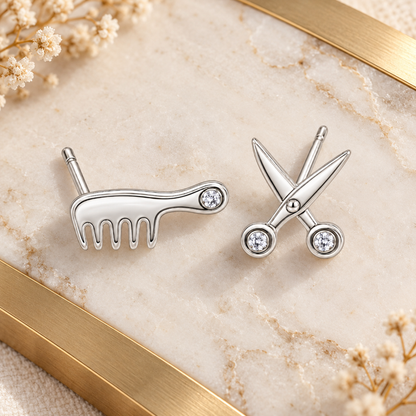 Silver salon stud earrings laid flat on honed ivory marble.