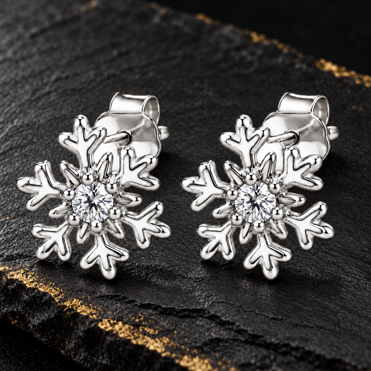Silver snowflake earrings placed in a blush pink tray on cream linen.