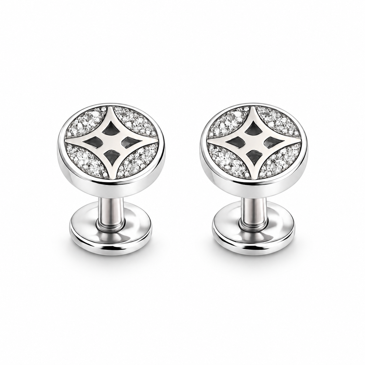Silver star pave stud earrings resting on an ivory stone tile next to blush pink linen fabric.