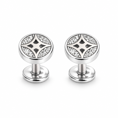Silver star pave stud earrings resting on an ivory stone tile next to blush pink linen fabric.
