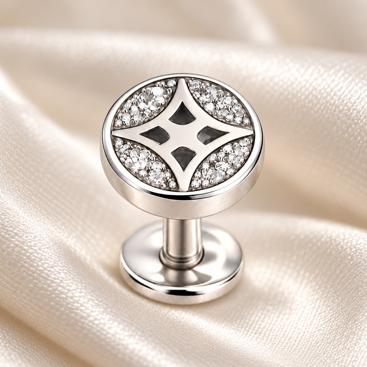 Macro view of clear cubic zirconia pave stones and four-pointed star cutout on a silver stud earring.