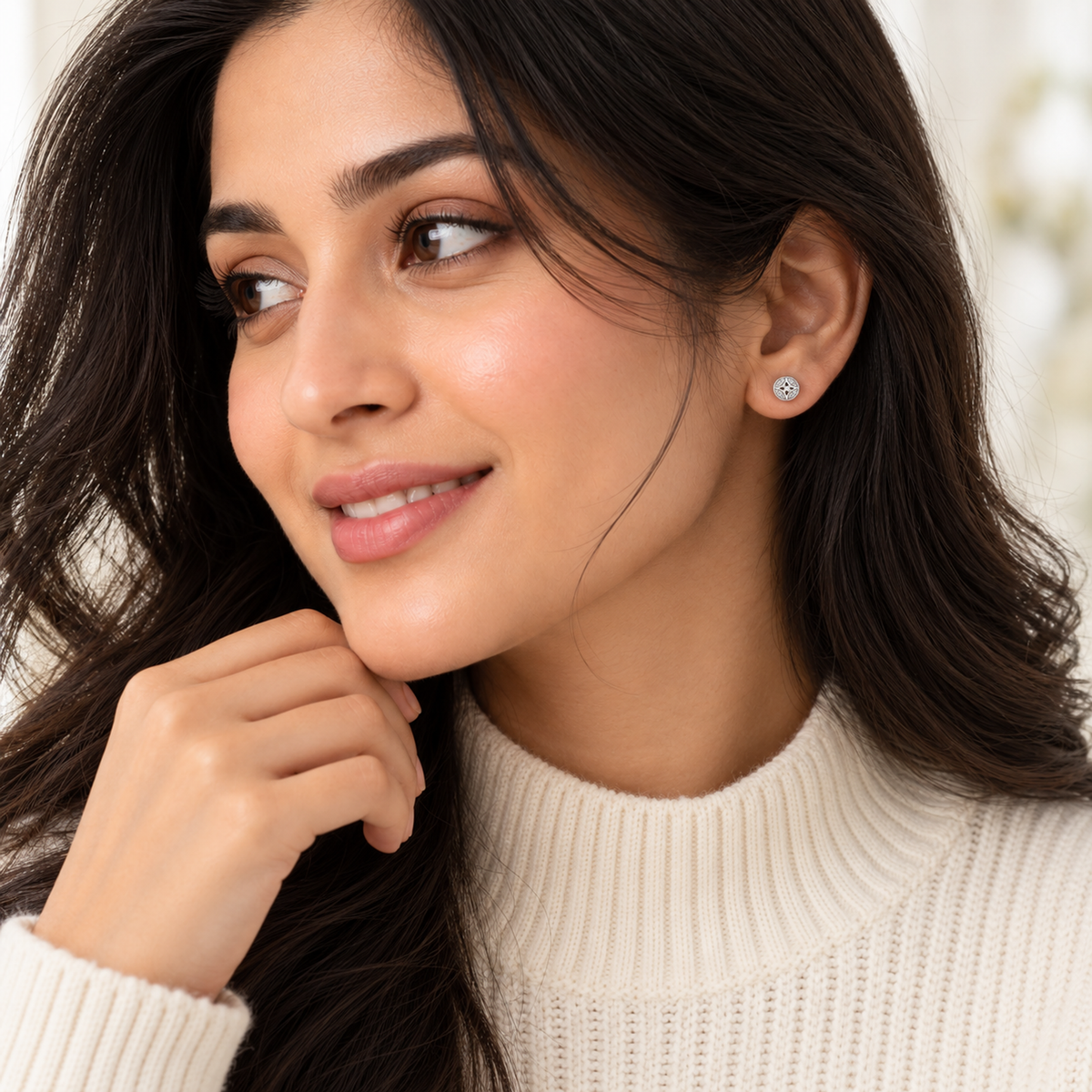 Close-up profile of a woman wearing a round pave star silver stud earring.