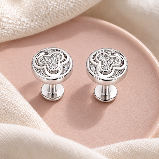 Silver stud earrings displayed on blush pink ceramic and ivory linen