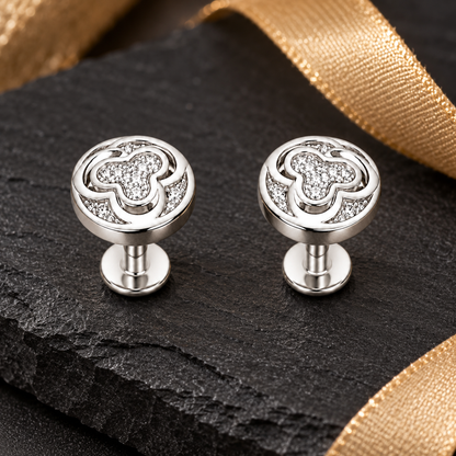 Silver swirl studs styled on dark slate with warm gold accents