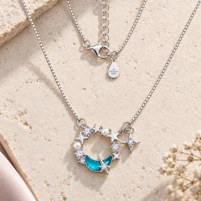 Flat lay of silver celestial wreath necklace on white ivory limestone surface.