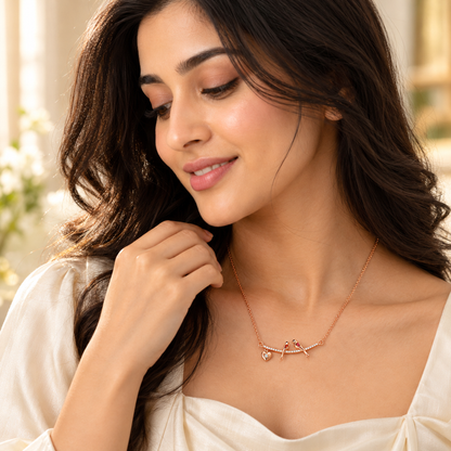 Model wearing rose gold lovebirds silver necklace on a cream silk blouse.