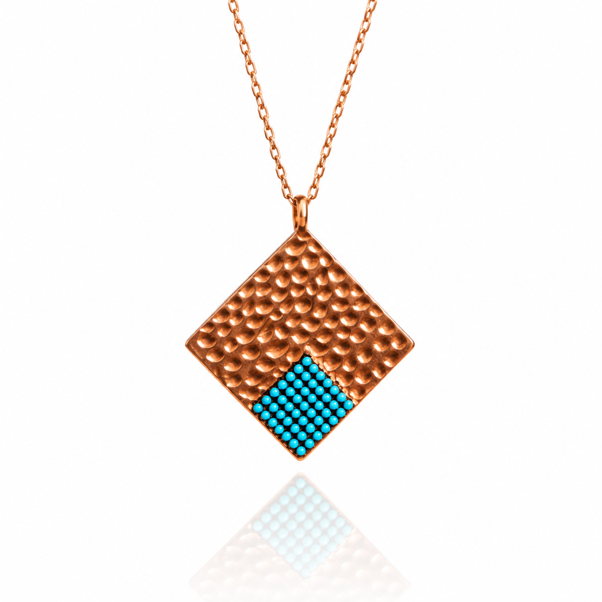 Diamond-shaped rose gold pendant with blue turquoise accent on white background.