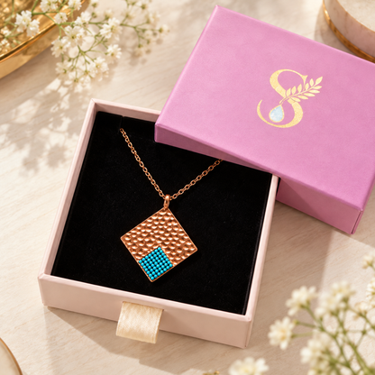 Silvanya pink jewelry gift box open displaying a turquoise rose gold pendant.
