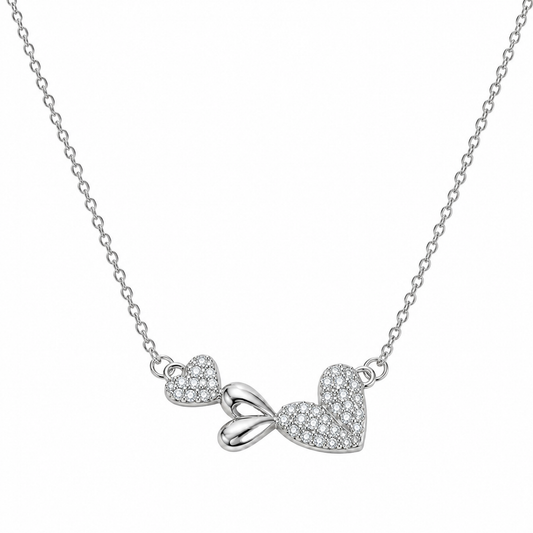 Silver necklace with dual heart and bow pendant centered on a clean white background.