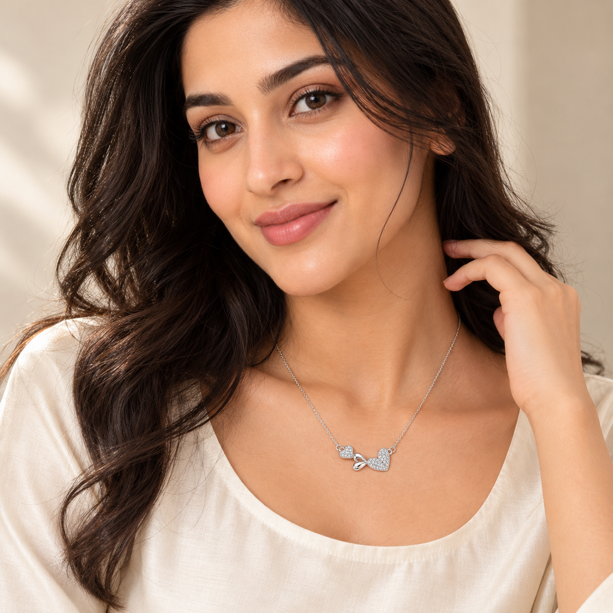 Noya wearing a delicate silver necklace facing forward in a clean indoor setting.