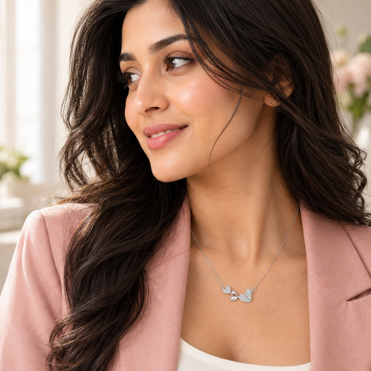 Close-up profile of Noya wearing a silver heart necklace against soft lighting.
