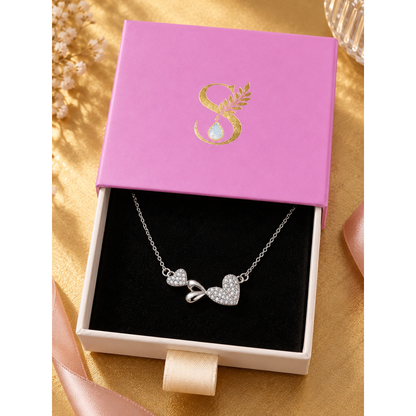 Silver necklace displayed inside a signature Silvanya pink box with black velvet lining.