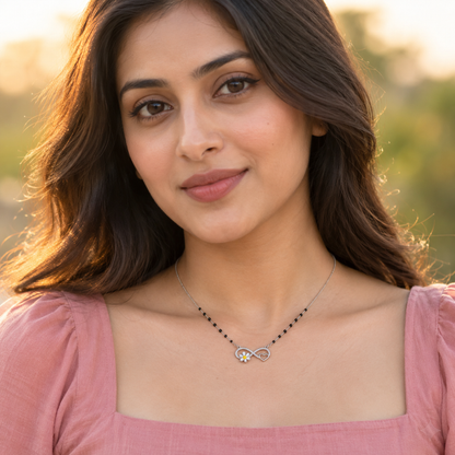 Close-up of a woman outdoors in golden hour light wearing a silver infinity pendant necklace.