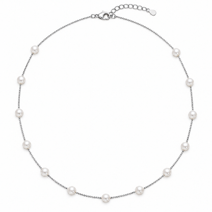 Silver box chain necklace with seven white pearls laid flat on a white background.