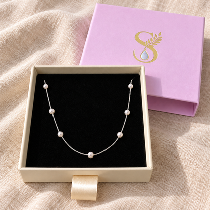 Silvanya magenta drawer box open on ivory linen showing the silver pearl necklace inside.