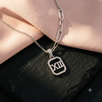Silver Roman numeral necklace on matte black stone and blush pink silk.