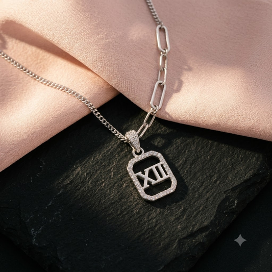 Silver Roman numeral necklace on matte black stone and blush pink silk.
