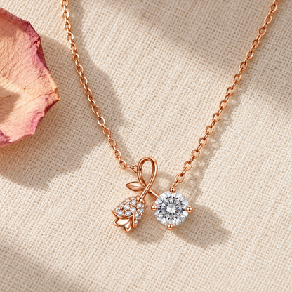 Rose gold dual pendant necklace lying gracefully on textured ivory linen beside a soft pink rose petal.