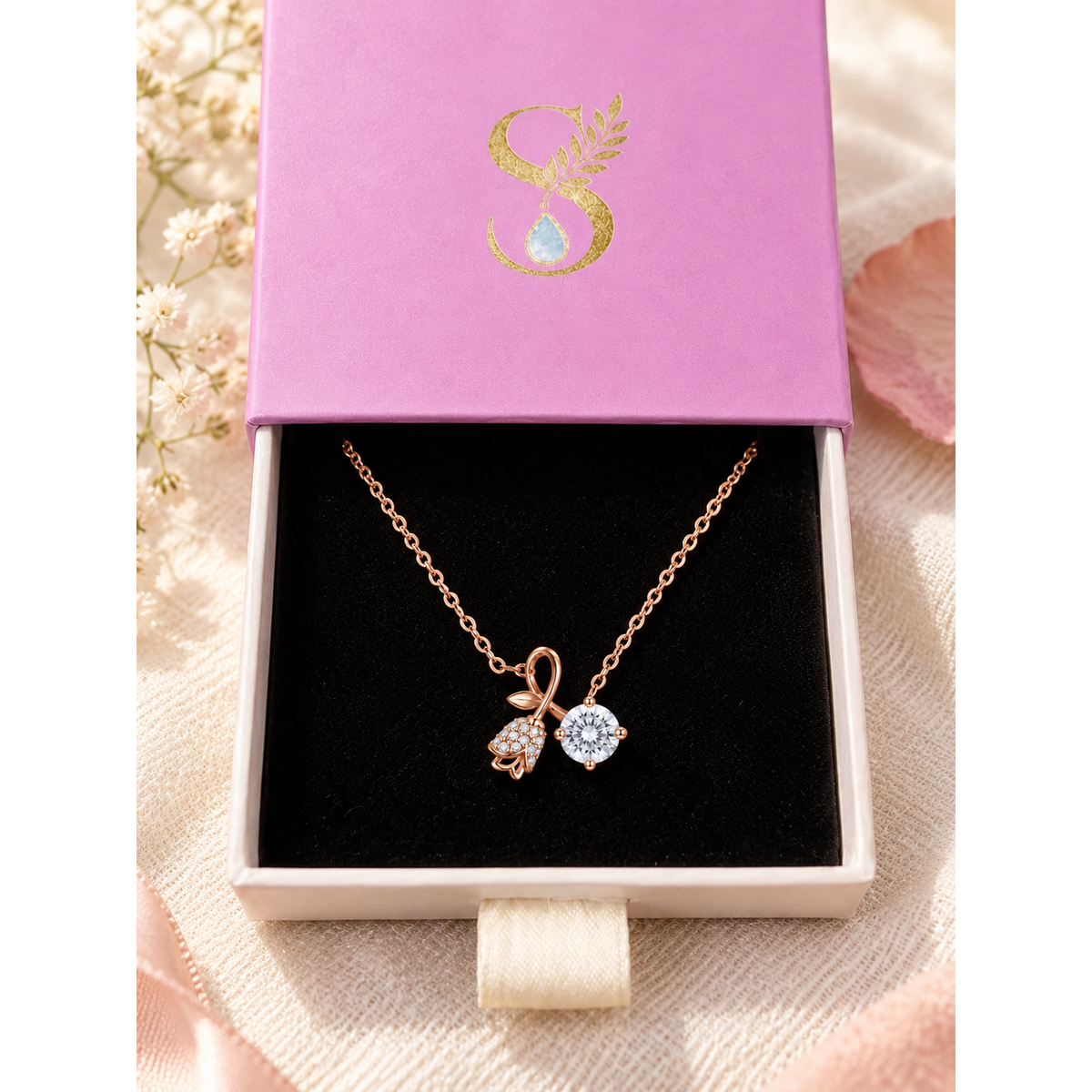 Rose gold pendant necklace displayed inside open pale pink Silvanya jewelry box on black velvet.