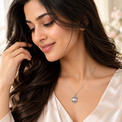 Noya wearing the shell pendant necklace, looking down thoughtfully.