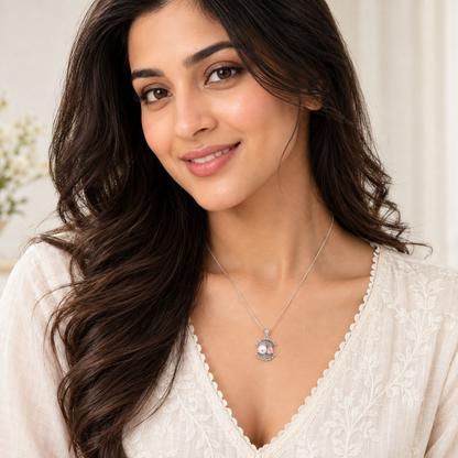 Noya smiling gently, wearing the shell pendant necklace, looking towards the camera.