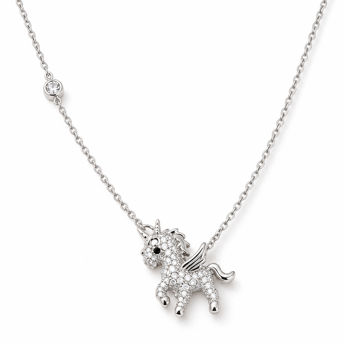 Silver unicorn pendant necklace with pave stones laid flat on a pure white background.