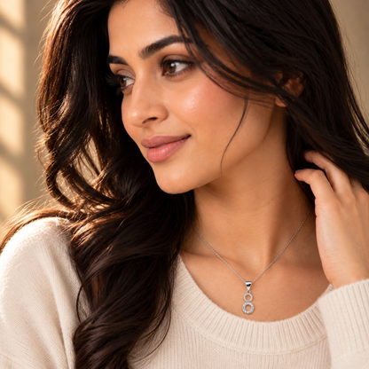 Noya wearing the silver double circle pendant against an off-white sweater.