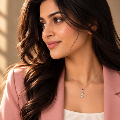 Profile shot of Noya wearing the dual ring pendant with a pink blazer.