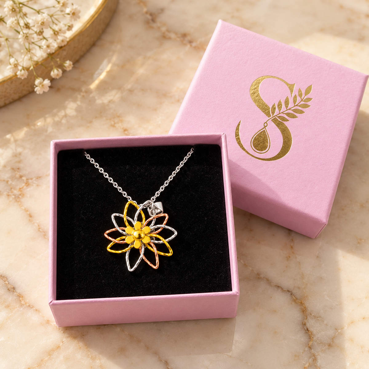 Three-tone silver pendant inside a pale pink Silvanya jewellery box with black velvet interior.