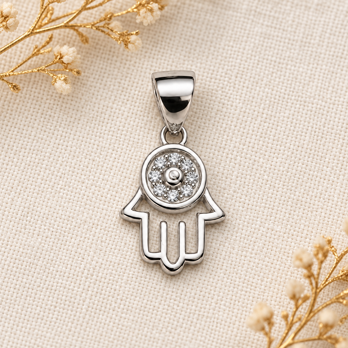 Woman wearing a delicate silver Hamsa pendant resting near her collarbone, dressed in an ivory shirt.
