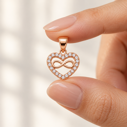 A woman holding a tiny 8mm rose gold heart pendant between her fingers to show size.